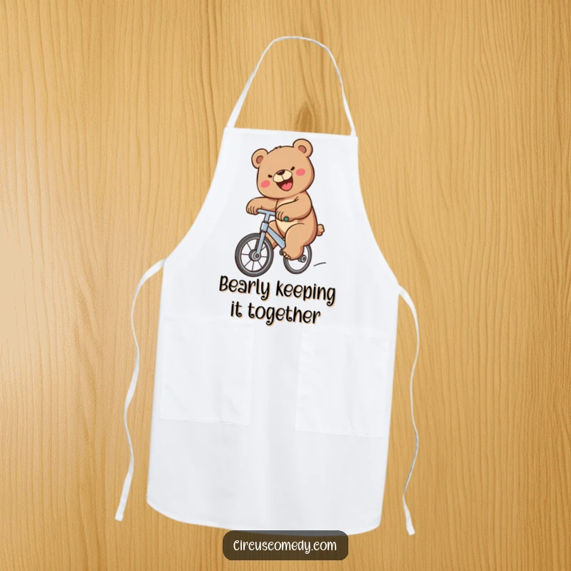 Funny Bear Unicycle Apron showing a determined bear with a big smile riding a unicycle while cooking, adding humor to the kitchen, a funny gift.