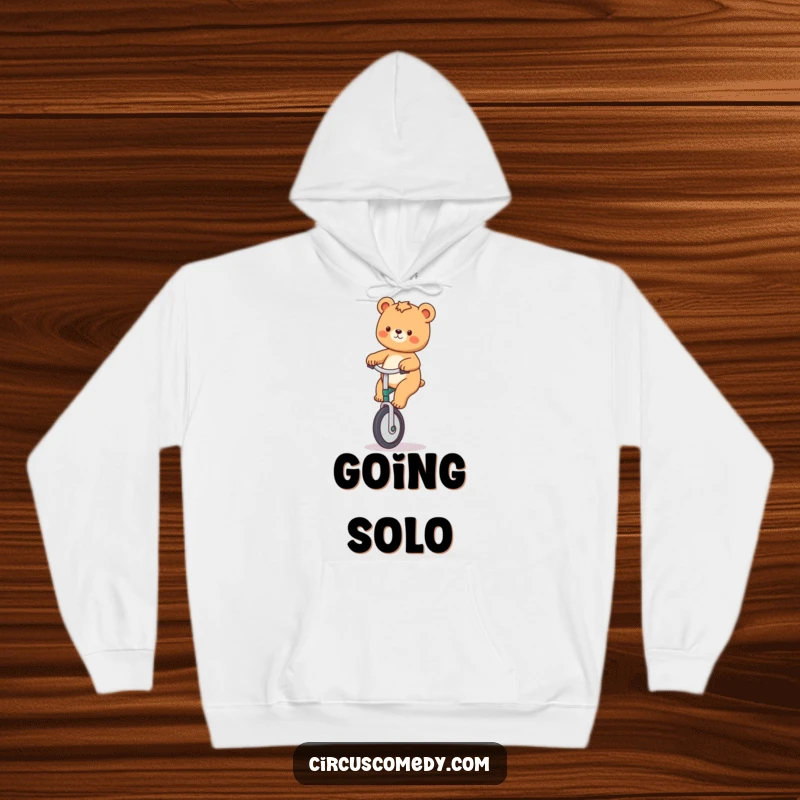Funny hoodie displaying a playful bear confidently riding a unicycle, conveying a sense of fun and daring.