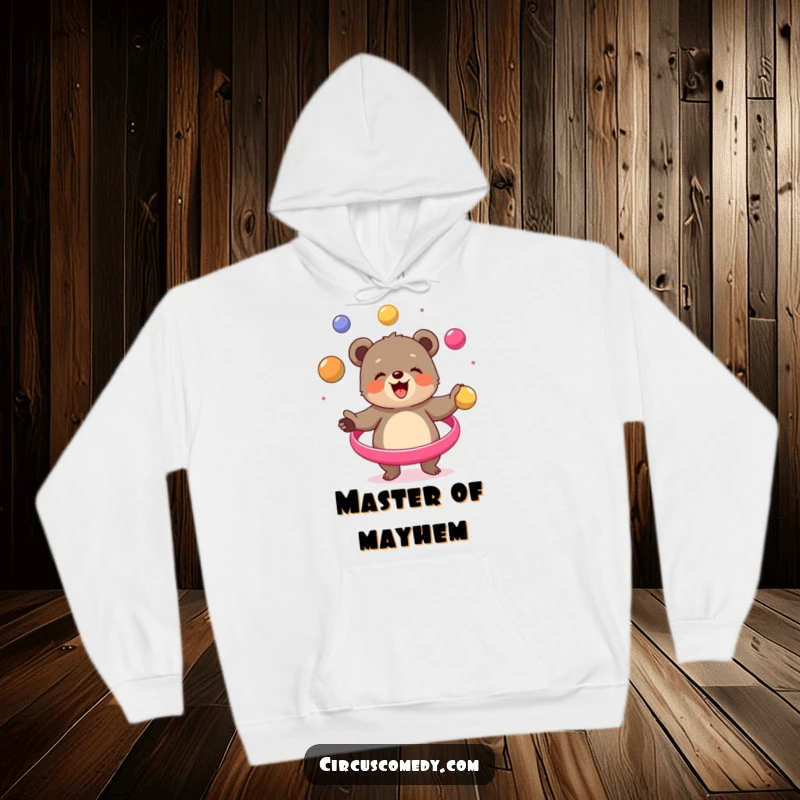 Funny bear cub hoodie, enthusiastically juggling multiple balls in a circus scene, radiating happiness, a humorous and warm apparel choice.