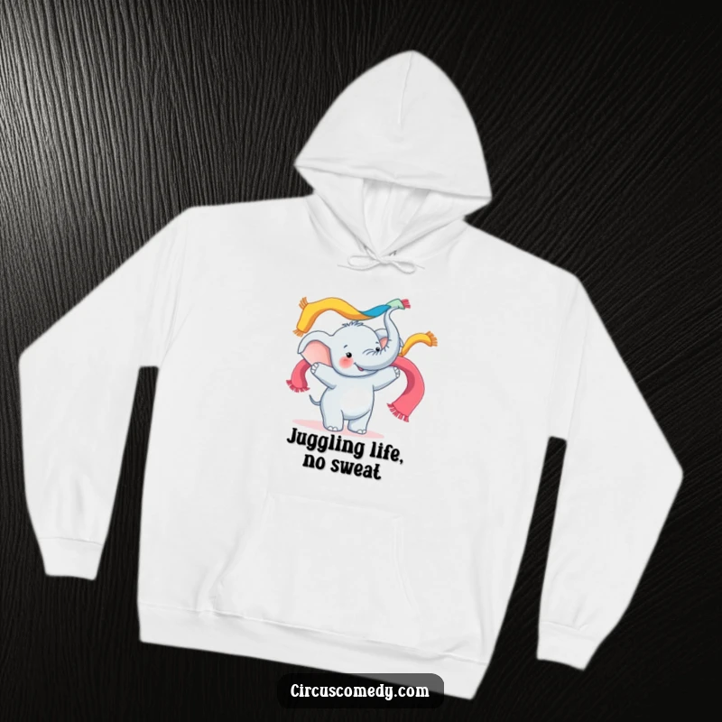 Funny hoodie design of a happy elephant joyfully juggling bright, flowing scarves with its trunk, embodying playful energy.