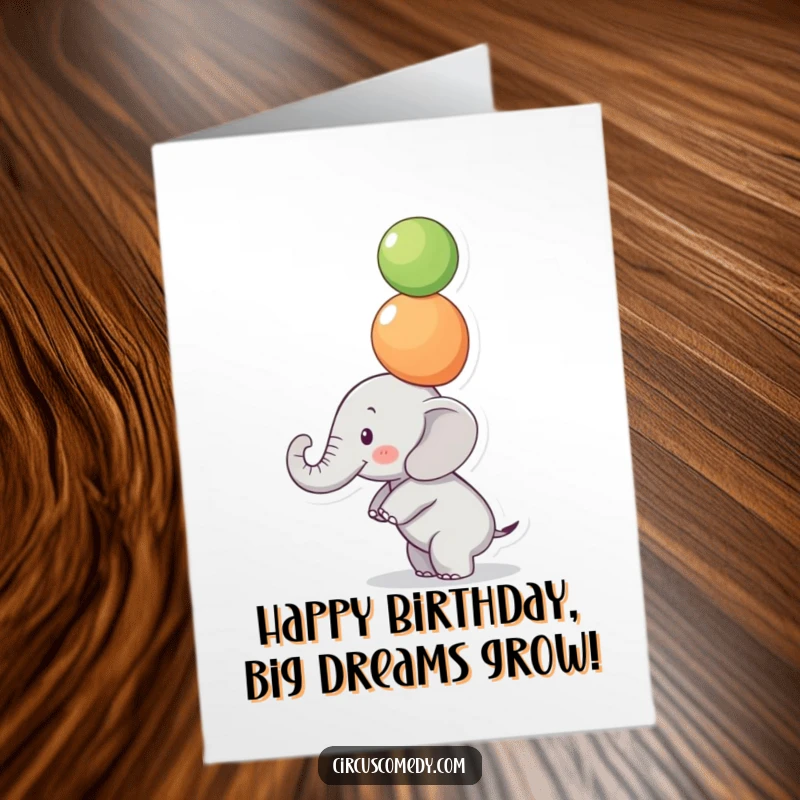 Funny Free Printable Birthday Card: A small elephant concentrates intensely while balancing colorful balls on its trunk.
