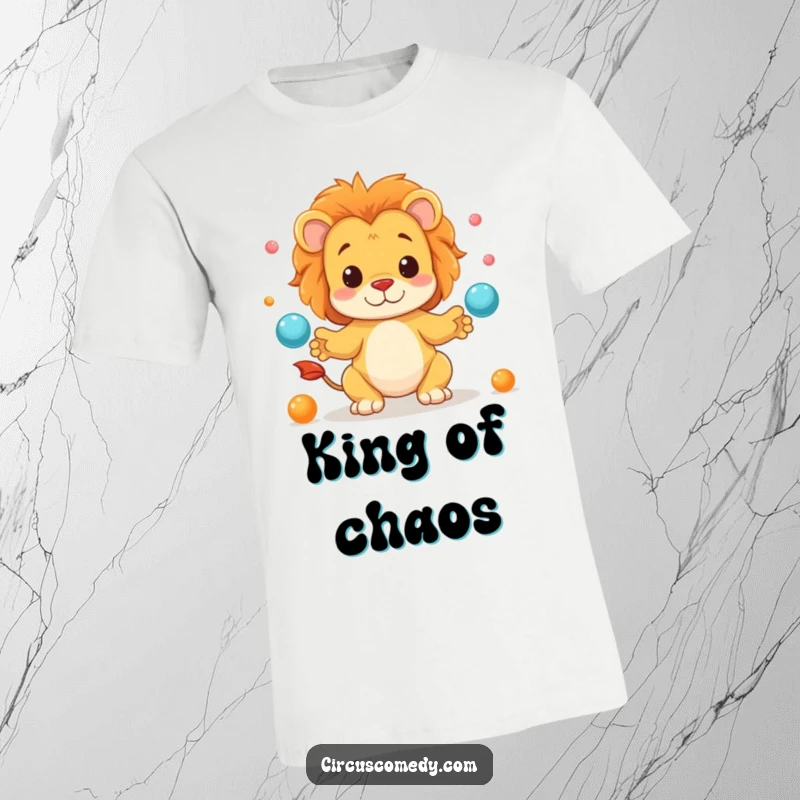 Funny t-shirt depicting a cheerful lion artistically juggling miniature spheres with impressive dexterity and a goofy grin.