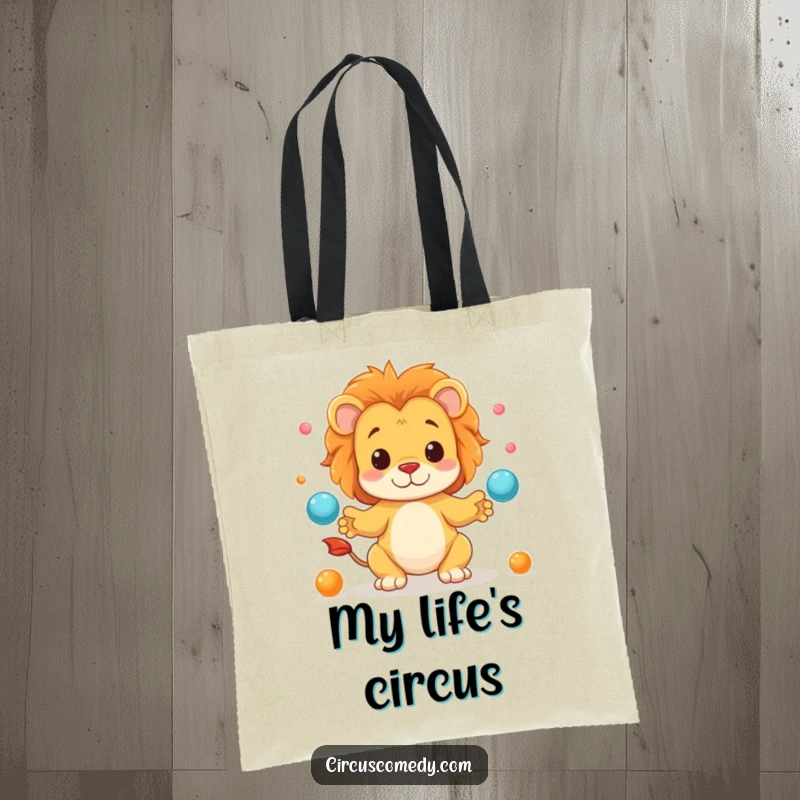 Funny tote bag with a cute, focused lion performing a juggling act with tiny orbs, demonstrating skill and amusement.